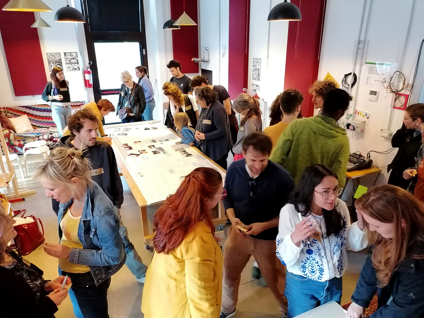 People gathering in small groups to exchange ideas at a S4T co-design event in the community academy La Foresta.