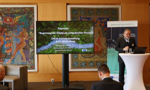 Wolfgang Münch vor Bildschirm auf Podium
