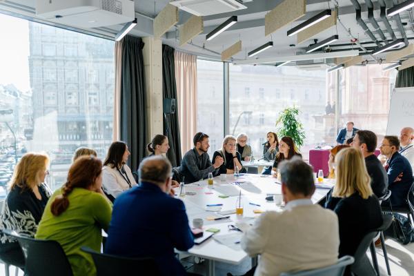 Diskutant:innen an einem Tisch