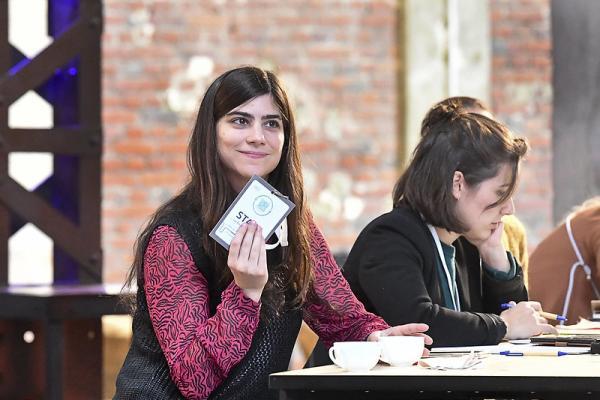 Weibliche Person an einem Tisch mit Karte in der Hand